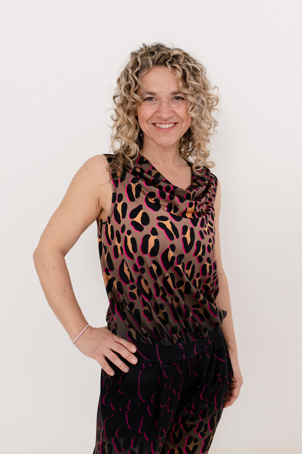 Frau mit blonden Locken und LeopardenmusterJumpsuit