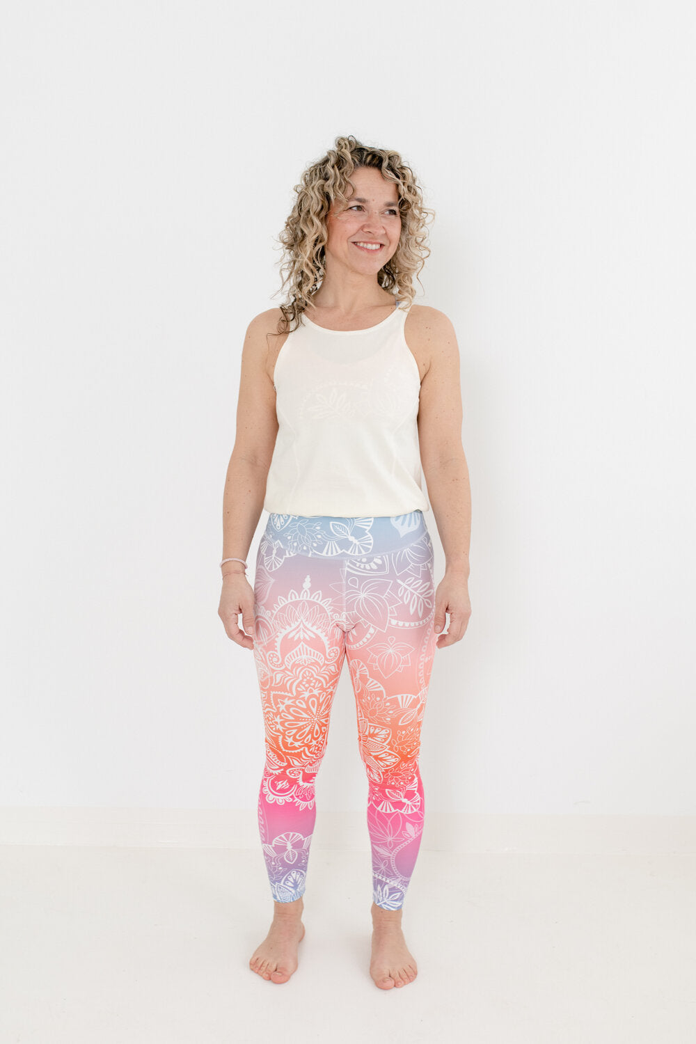 Yoga Jumpsuit mit hellem Oberteil und Sonnenaufgang-farbendem Unterteil in an Blondine mit Locken