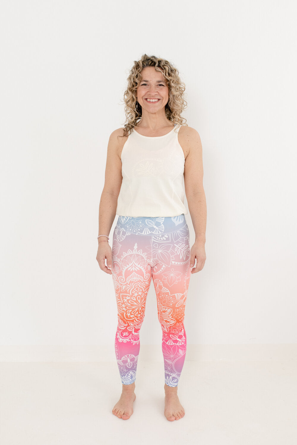 Yoga Jumpsuit mit hellem Oberteil und Sonnenaufgang-farbendem Unterteil in an Blondine mit Locken