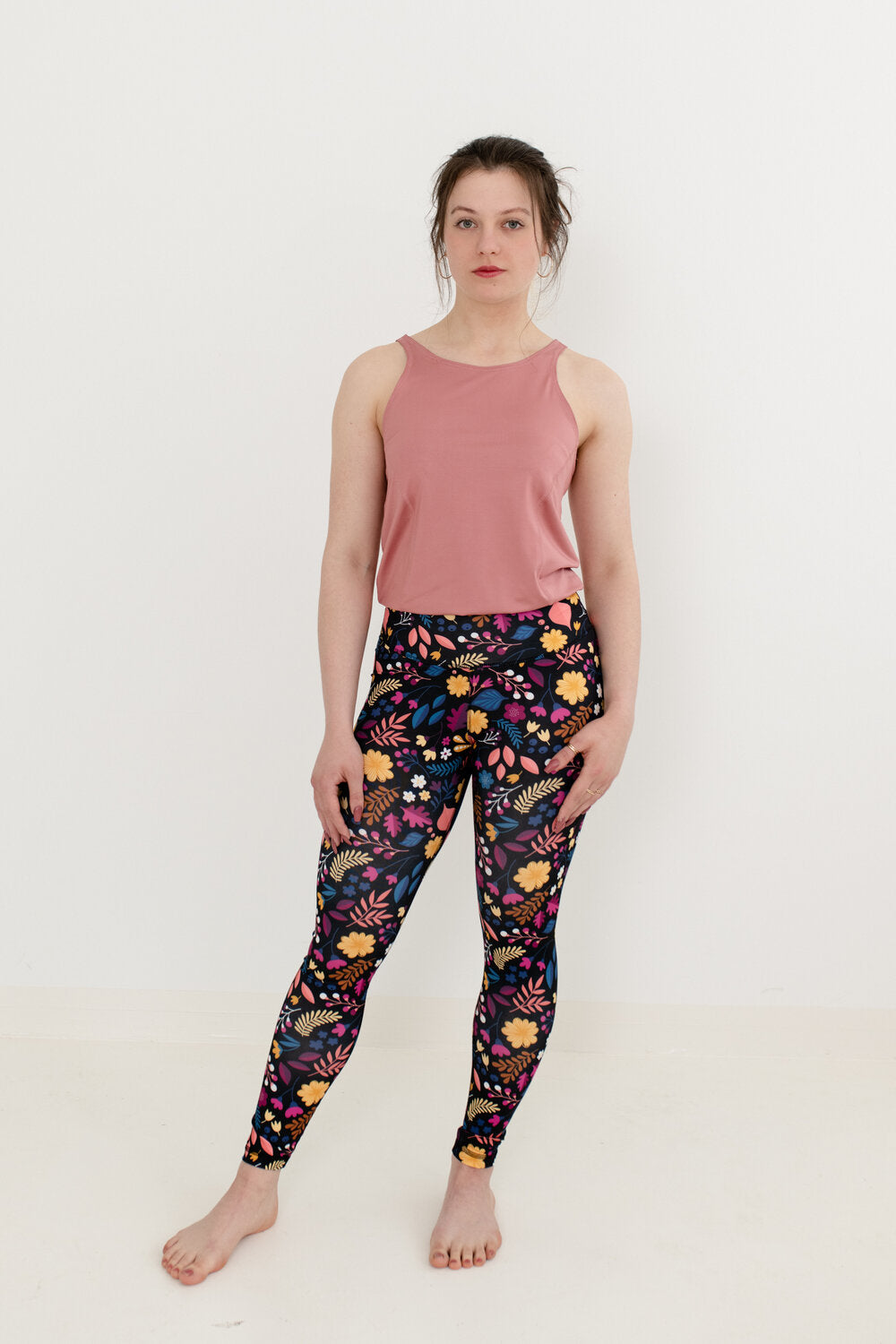 Brünette trägt einen altrosa Yoga Jumpsuit mit BlumenmusterUnterteil